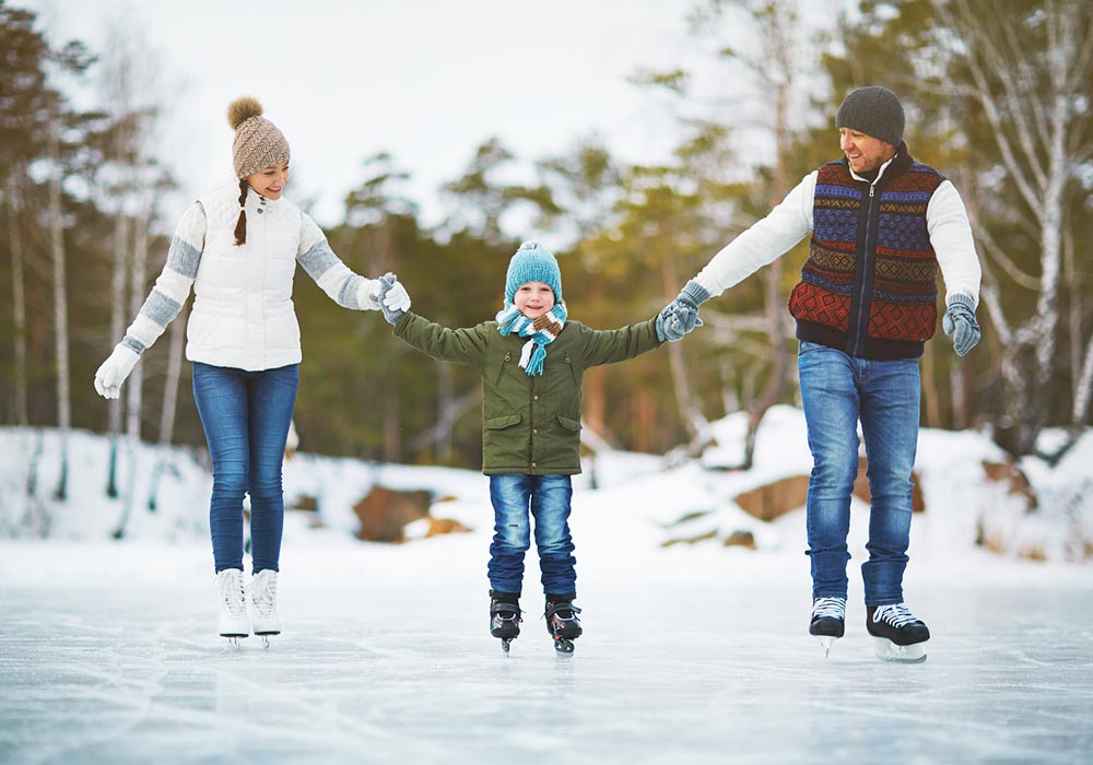 Parents skating on a pond with their young child