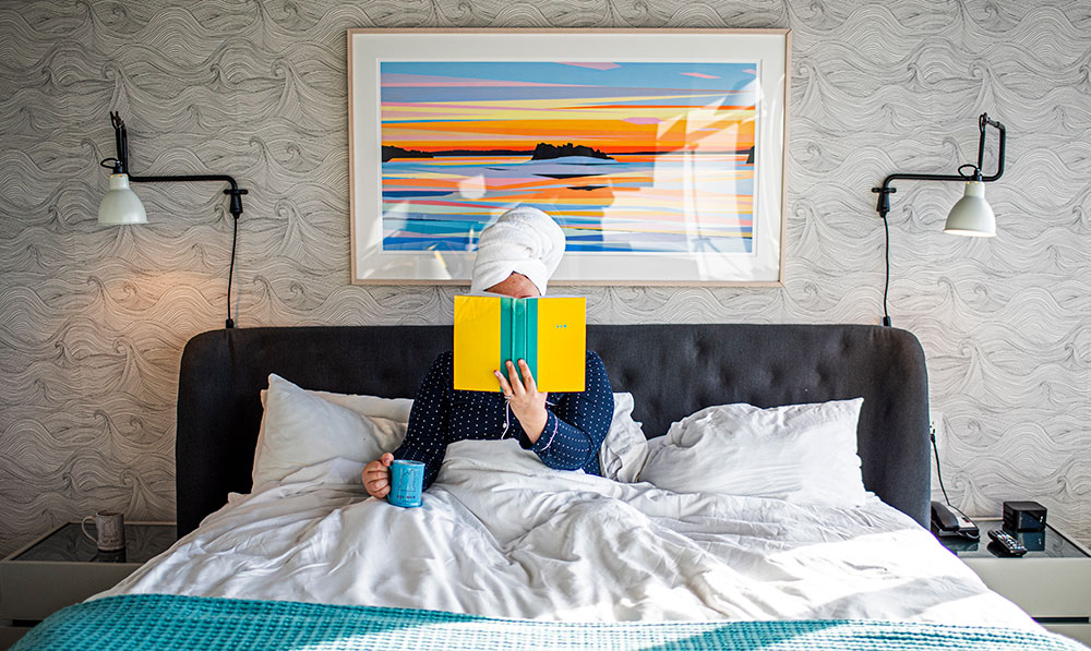 Woman relaxing in luxurious hotel room at 250 Main in Rockland, Maine