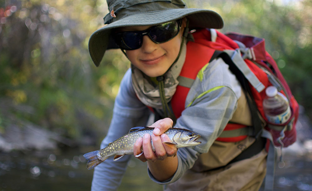 Young fisherman holding a brown trout