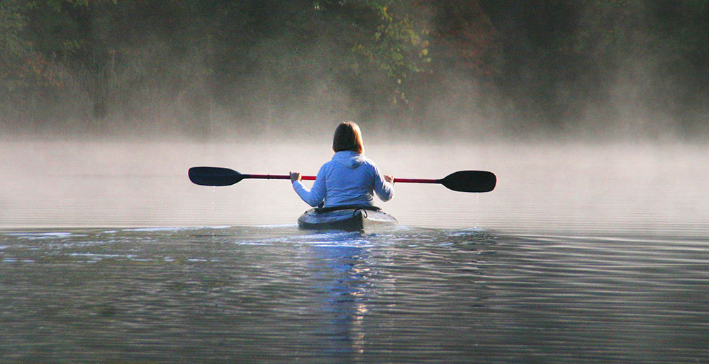 Woman enjoying a quiet moment kayaking in Maine