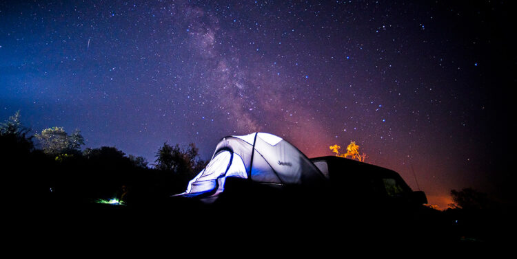Night sky and lit-up tent at Hermit Island Campground, Phippsburg, Maine