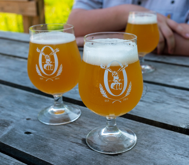 Glasses of beer on a picnic table at Oxbow Brewing in Newcastle, Maine