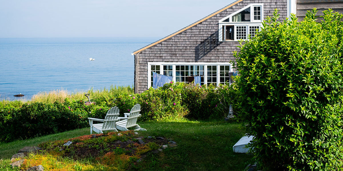 Adirondacks on the lawn facing the ocean, next to a cedar shingled building, Monhegan Island, Maine
