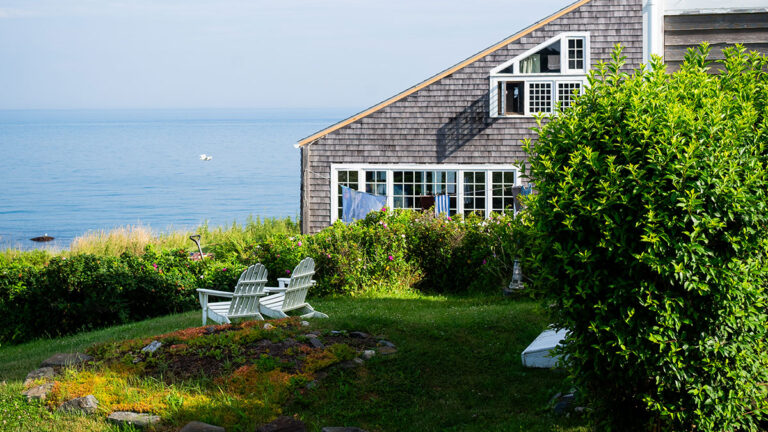 Adirondacks on the lawn facing the ocean, next to a cedar shingled building, Monhegan Island, Maine