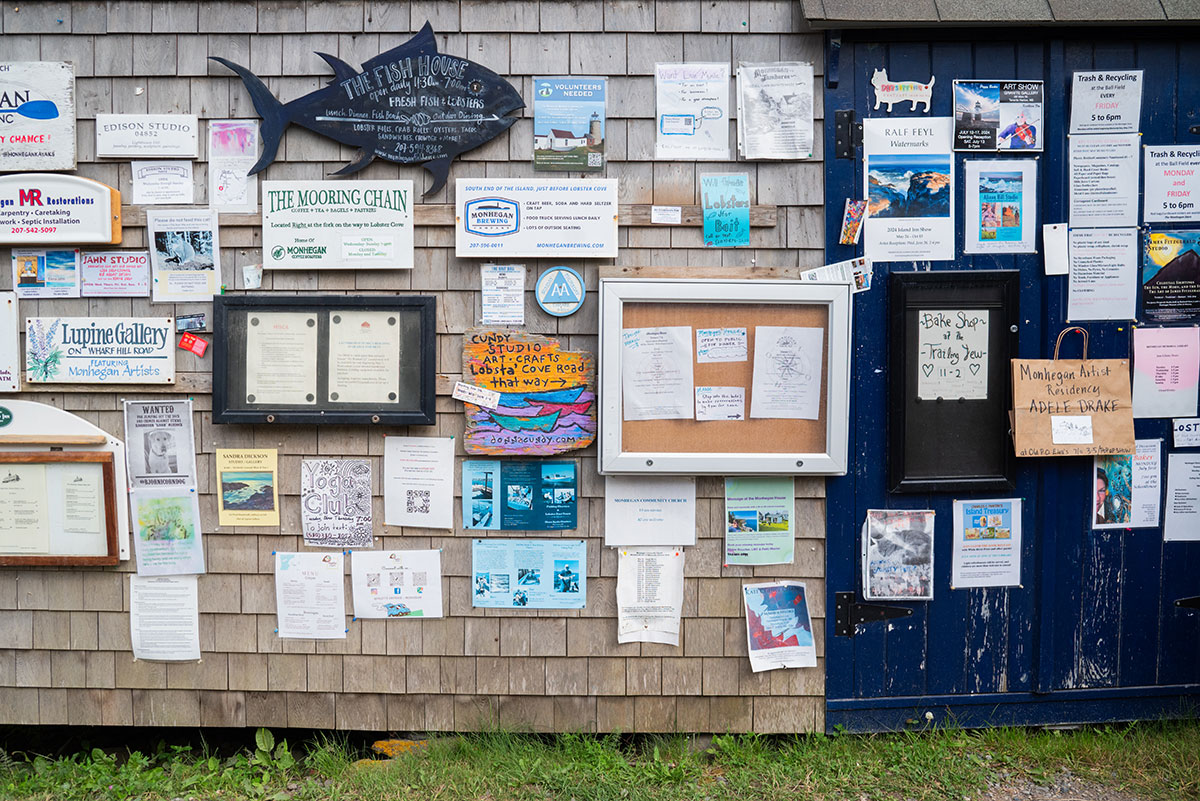 Bulletin board with many, varied postings for galleries, restaurants and varied services, Monhegan Island, Maine