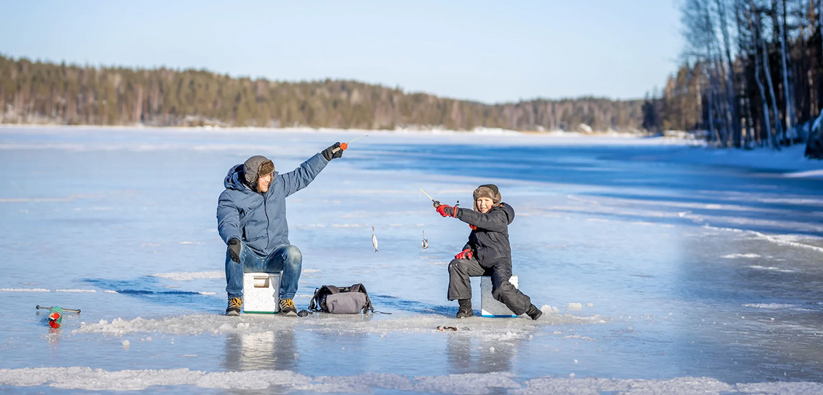 Father and son ice fishing on a Maine lake